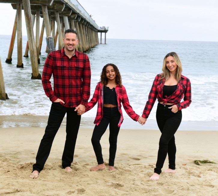 Owners family wearing matching red flannel shirts on the beach.
