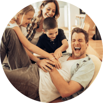 family tickling dad on the ground
